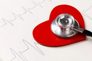 Red heart on cardiogram with stethoscope atop