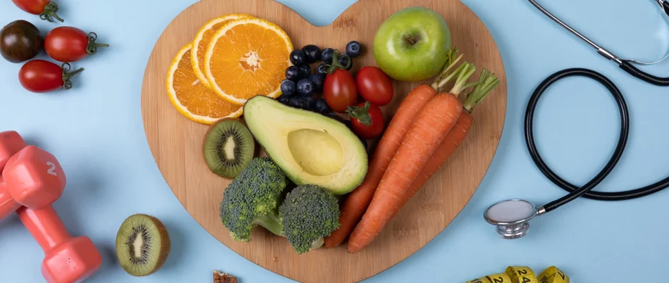 Cutting board with fruits and vegetables and scattered fruits around board alongside stethoscope