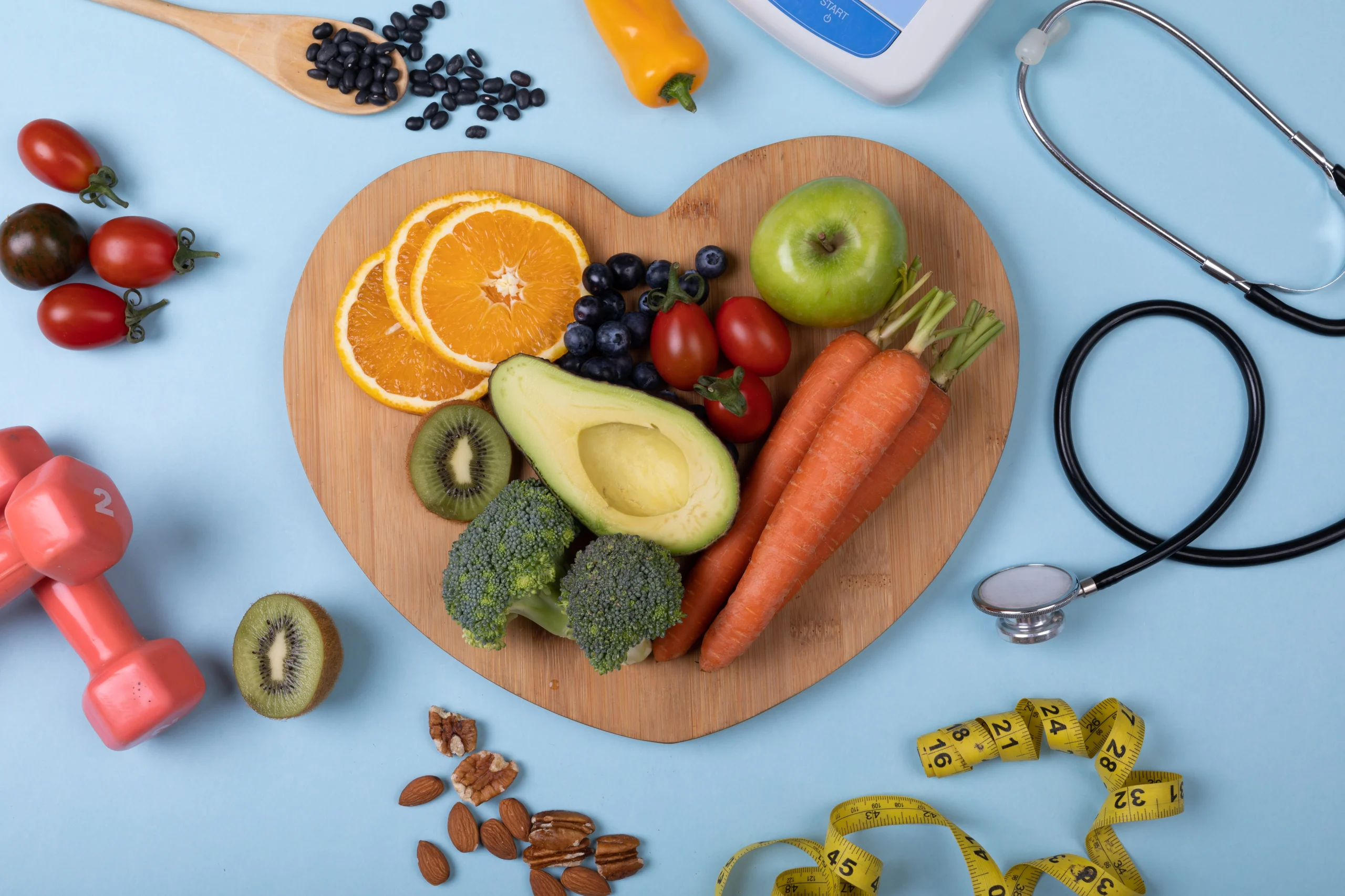 Cutting board with fruits and vegetables and scattered fruits around board alongside stethoscope